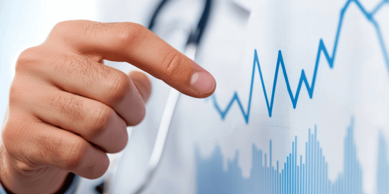 A faceless doctor pointing at a blue medical chart. 