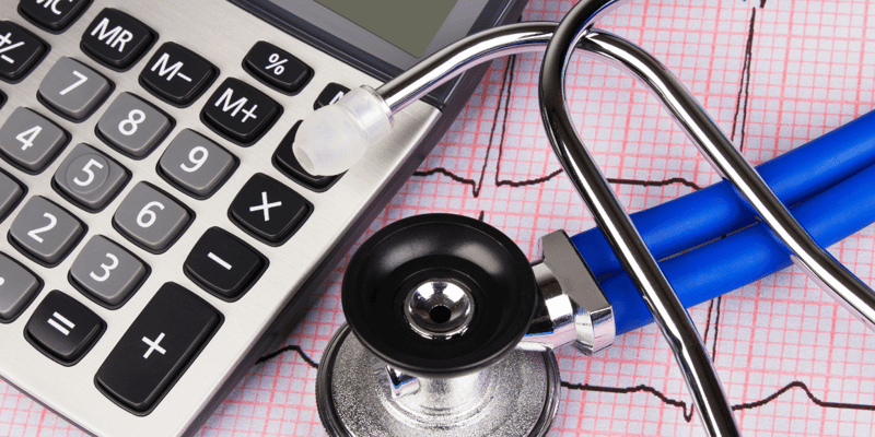 Calculator and stethoscope on ECG graph paper.